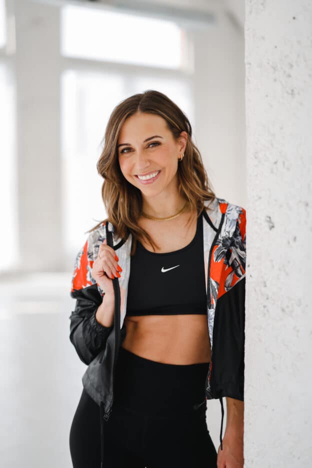 Woman in workout clothes looking overwhelmed — how the all-or-nothing mindset is sabotaging your fitness progress