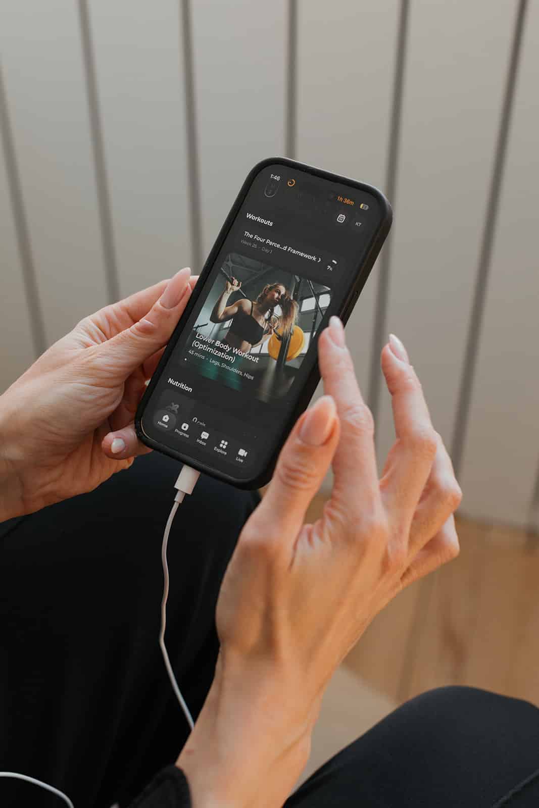 Woman sitting on gym floor looking frustrated — why you keep falling off your workout routine and how to stop